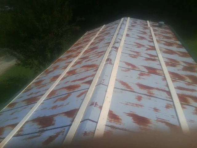 Rusted metal roof panels with new wood purlins before replacement — Storm Damage Roof Repair in Riegelwood by Roofing Brothers
