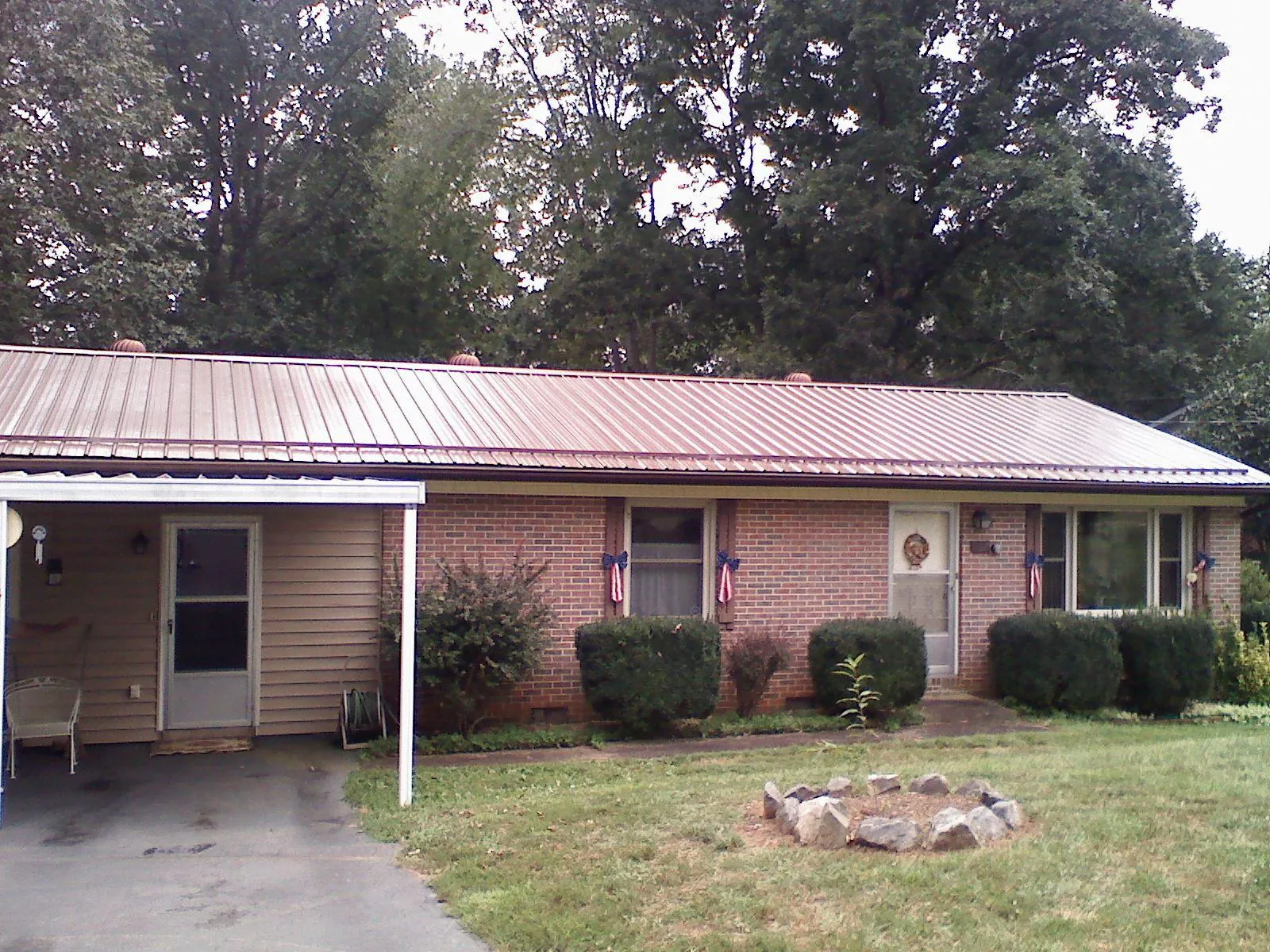 Bronze metal roof and carport on a brick ranch home — Roof Repair work by our crew in Riegelwood