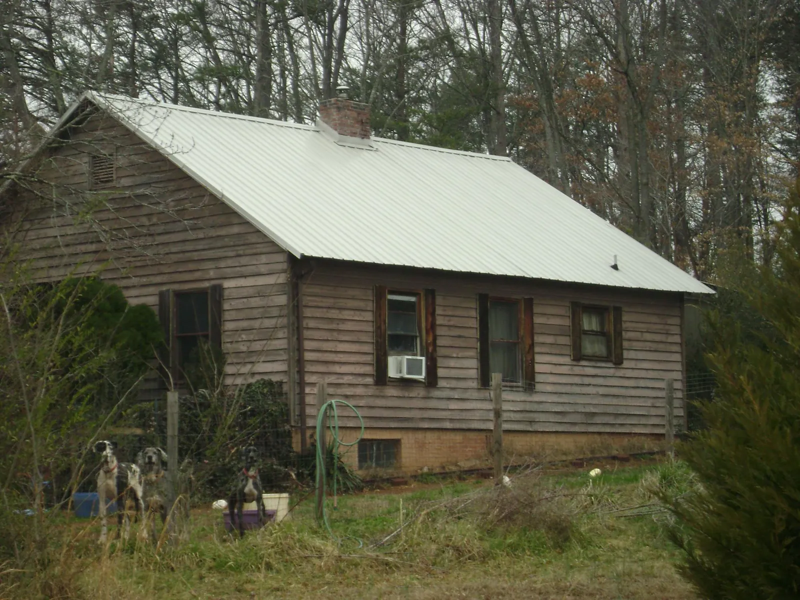 White metal roof on an old wood sided farmhouse, from a Metal Roof Installation job in Riegelwood